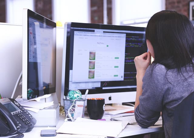 woman working on her double screen computer in an office