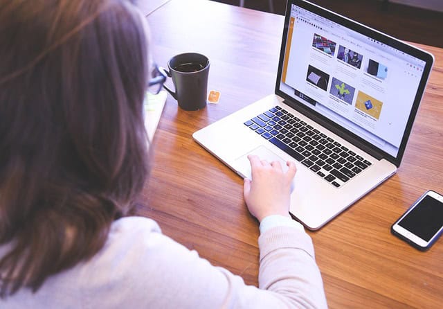 woman drinking a tea and working on her computer