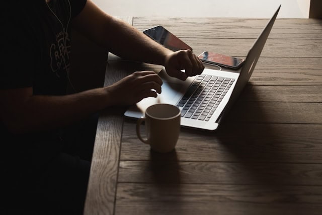person working on their computer and having a tea
